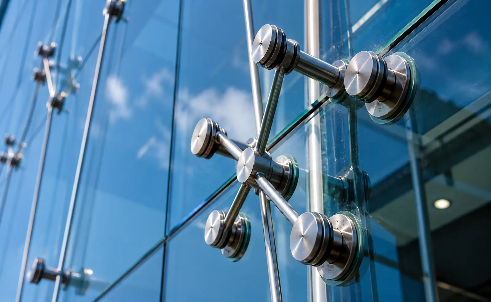 Glass Facade Contractors in Coimbatore using premium stainless steel spider fittings for frameless structural glazing systems.