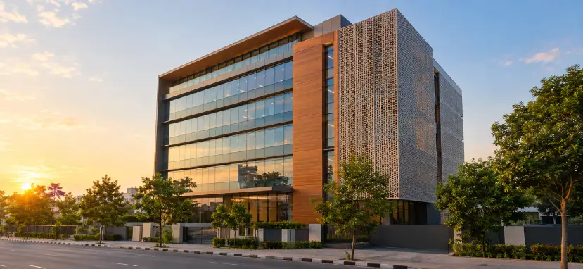 Modern Indian commercial building using mixed facade materials: solar control glass, wood-look HPL panels and metal screen